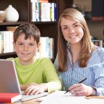Female Tutor Helping Boy With Home Studies