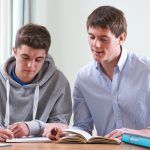 Teenage Boy Studying With Home Tutor